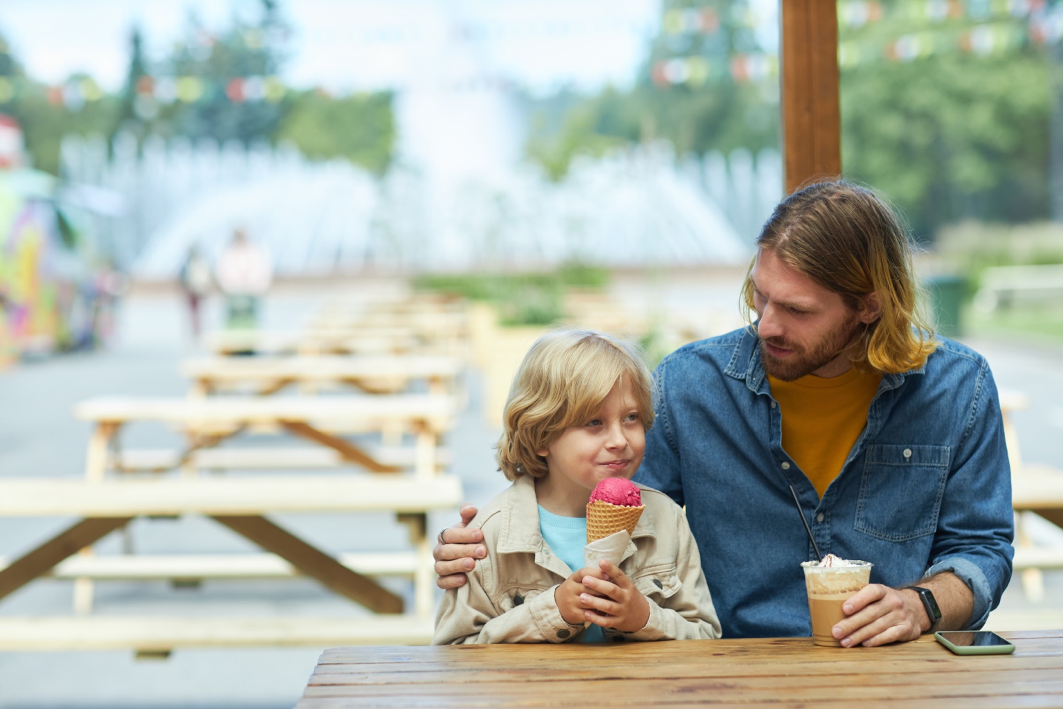 A father and son enjoying ice cream together at a picnic table