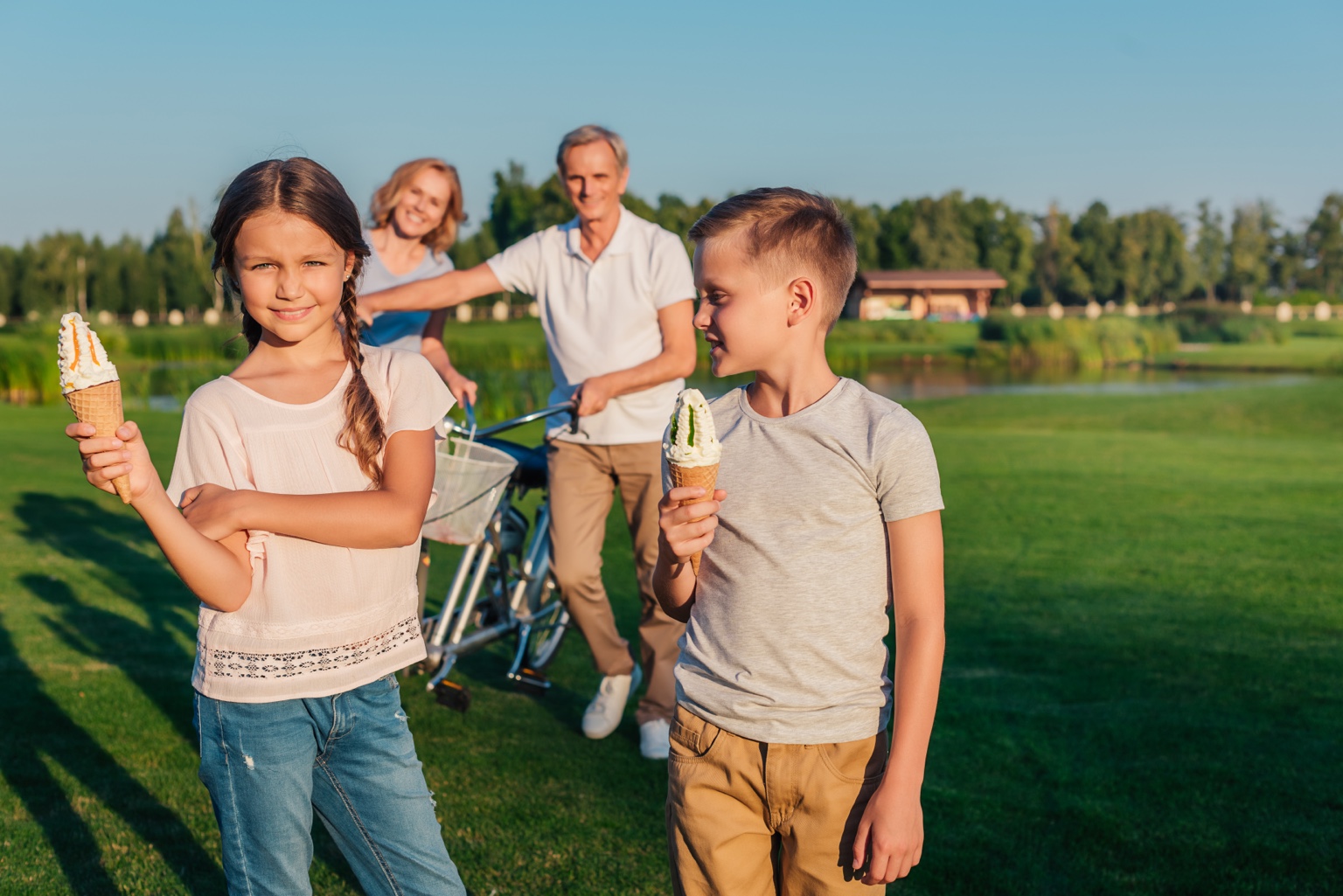 Family enjoying ice cream together in a sunny park